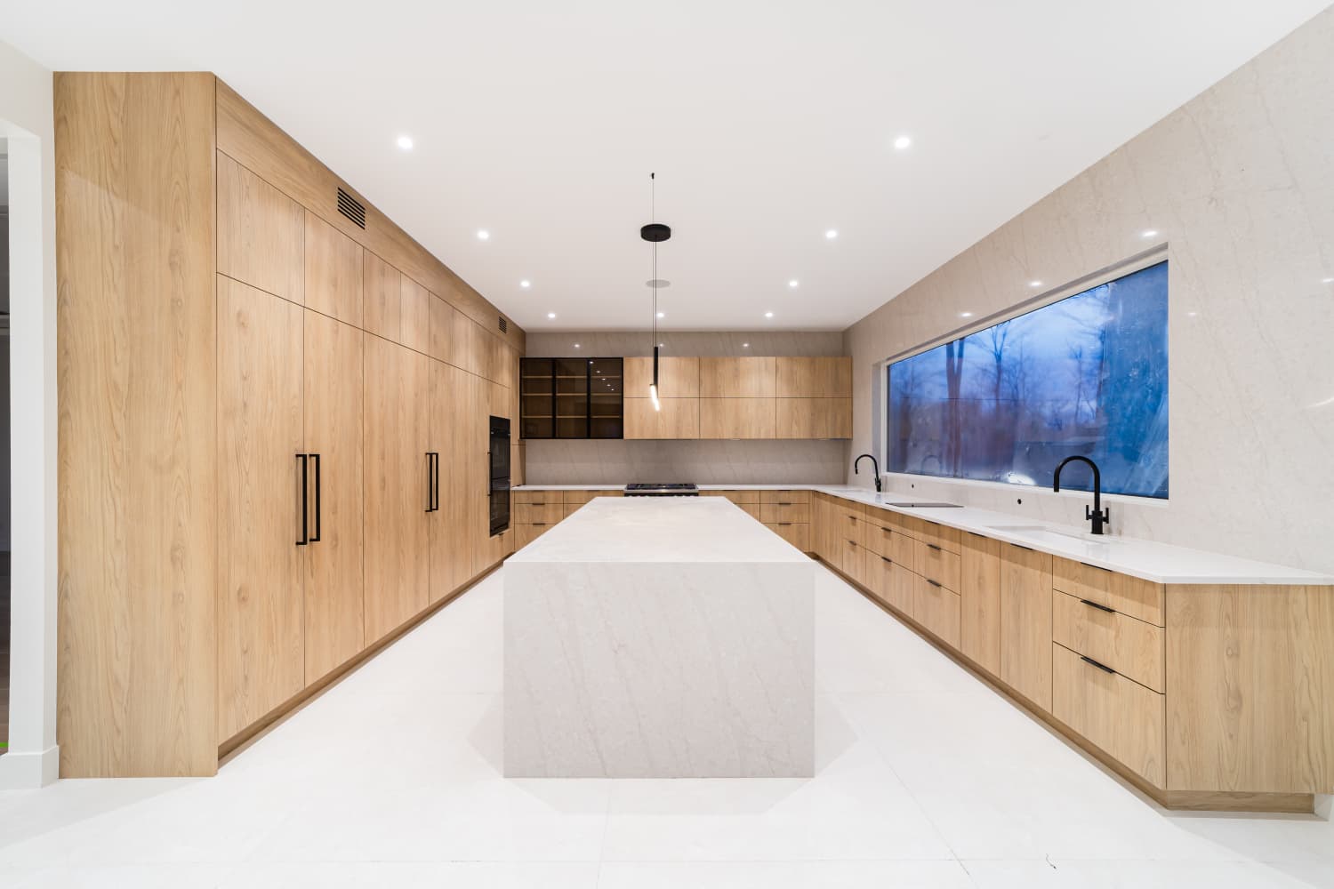 Light oak kitchen with stone countertops, angle 1